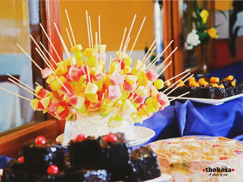 Catering platters with fruit skewers and desserts